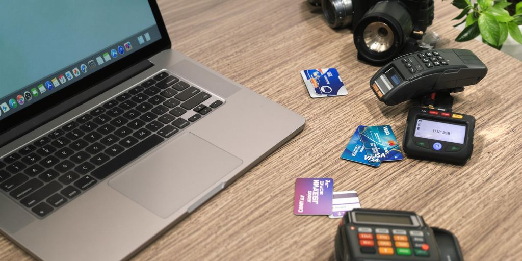 Laptop and credit cards on a sleek workspace.