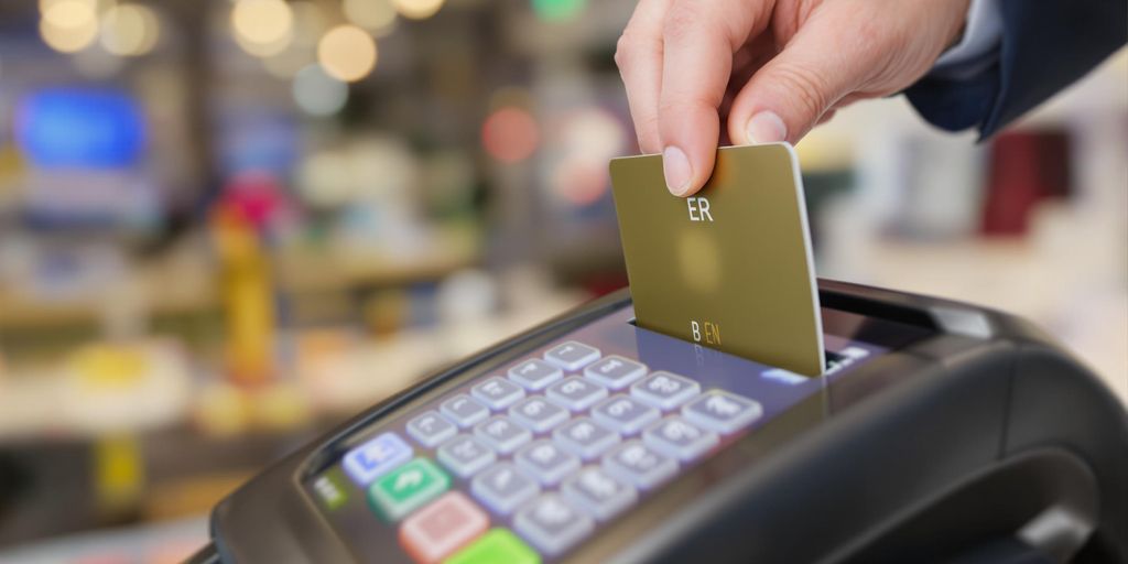 Close-up of a credit card being inserted into a terminal.